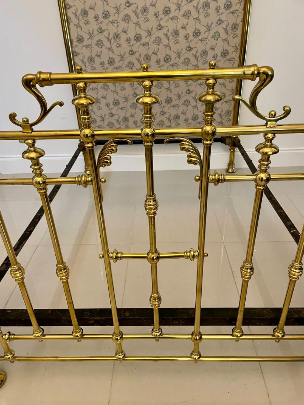 An antique Victorian solid brass half tester double bed featuring turned posts, spindle balusters, cast decorative mounts, and an upholstered floral panel. View XII