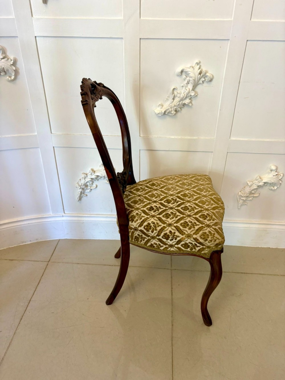 A set of six Victorian carved walnut dining chairs featuring open balloon backs, cabriole legs, and patterned green upholstered seats. View IV