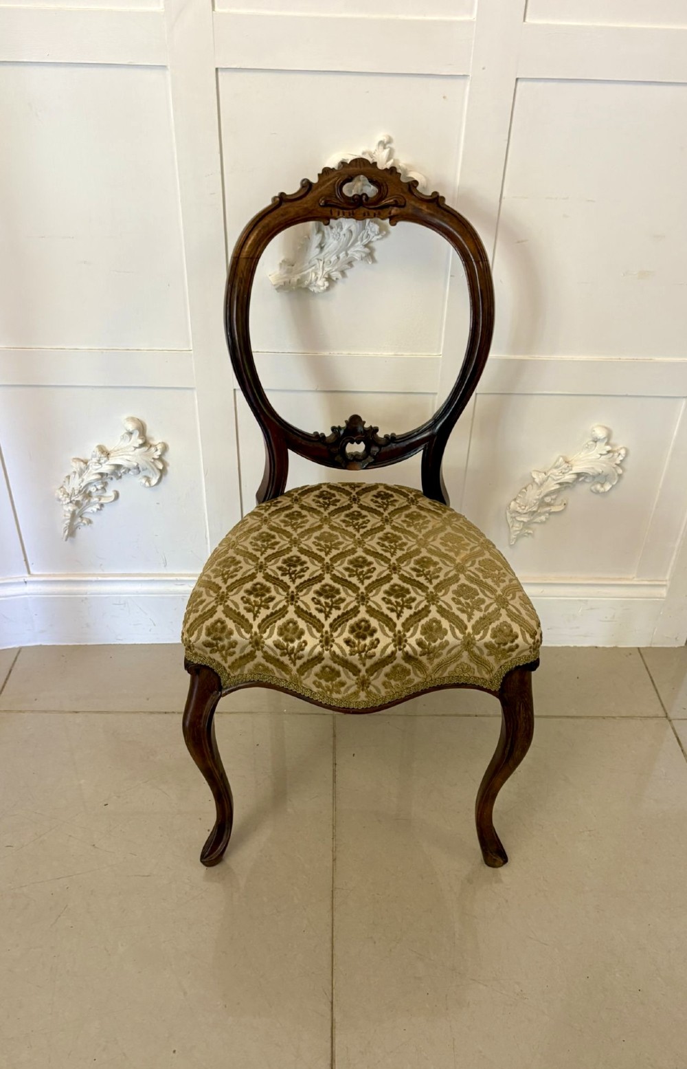 A set of six Victorian carved walnut dining chairs featuring open balloon backs, cabriole legs, and patterned green upholstered seats. View VI