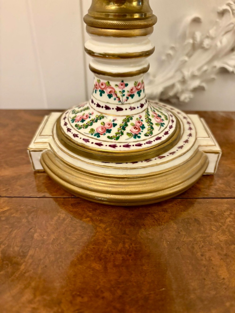 A French hand-painted porcelain urn-shaped mantel clock featuring gold leaf accents, cobalt blue borders, and pink floral garlands on a gilded pedestal base. View VI