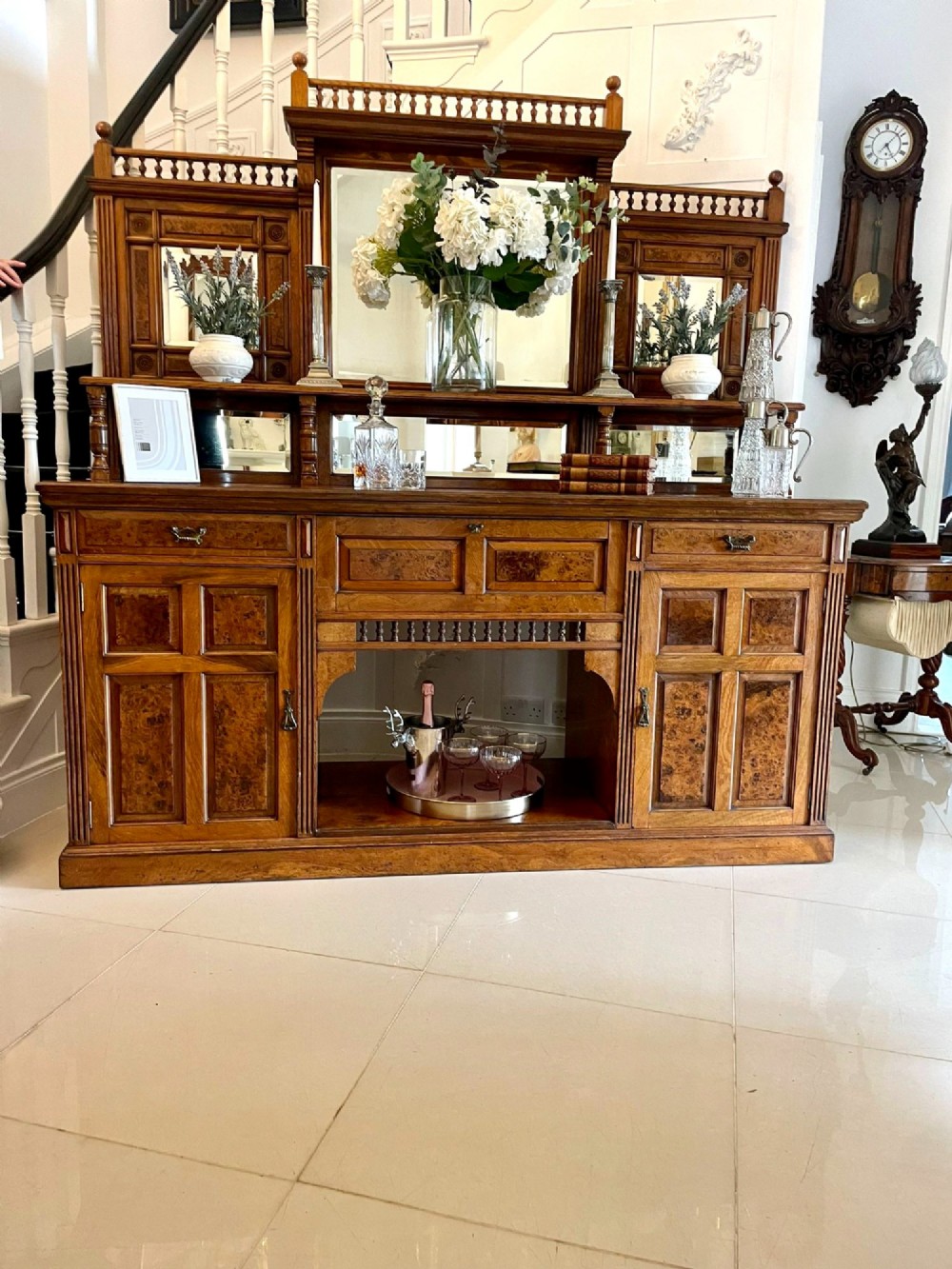 An antique Victorian pollard oak mirror-back sideboard featuring carved field panels, spindled galleries, and multiple mirrored sections. View II