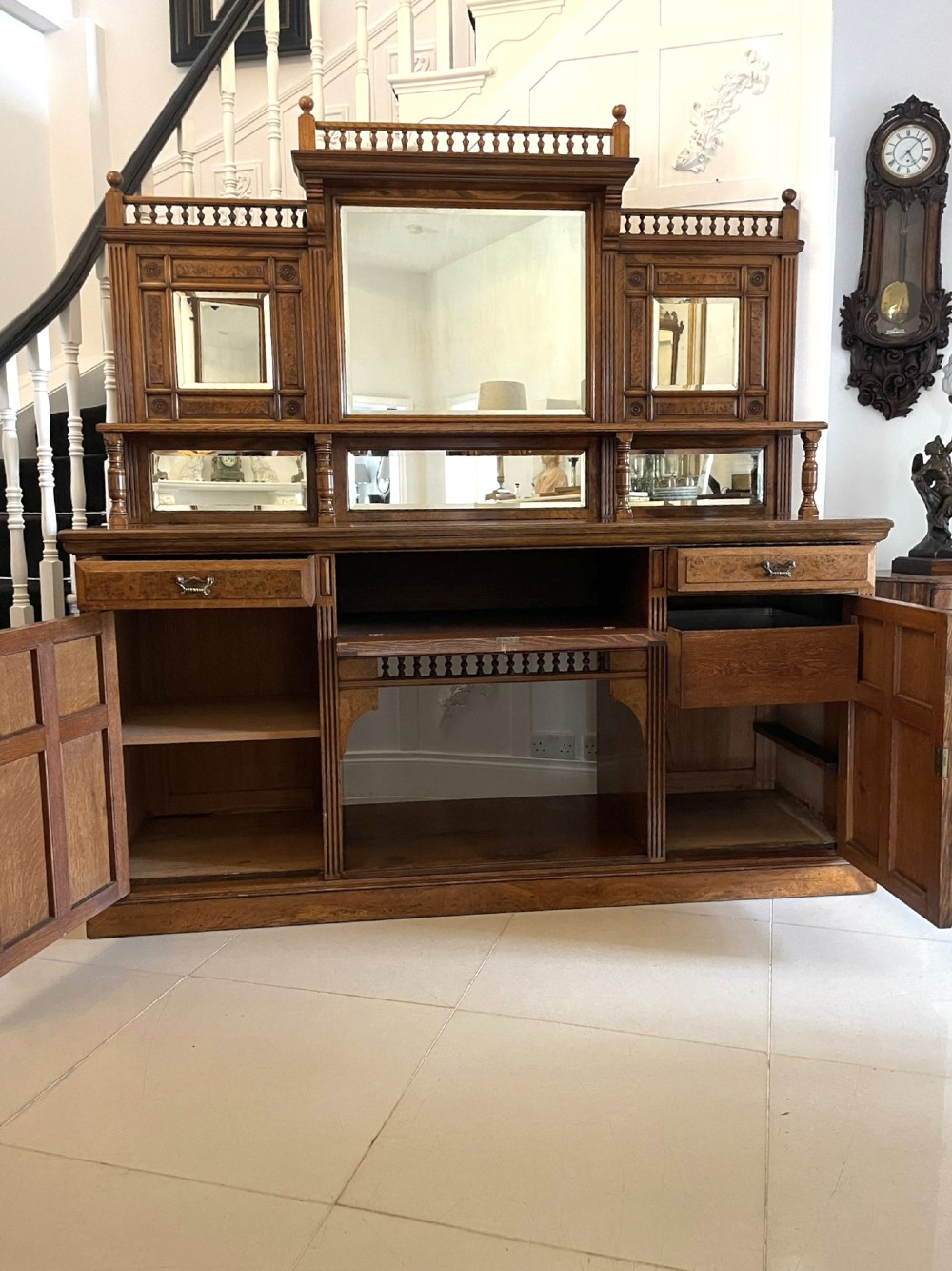 An antique Victorian pollard oak mirror-back sideboard featuring carved field panels, spindled galleries, and multiple mirrored sections. View III