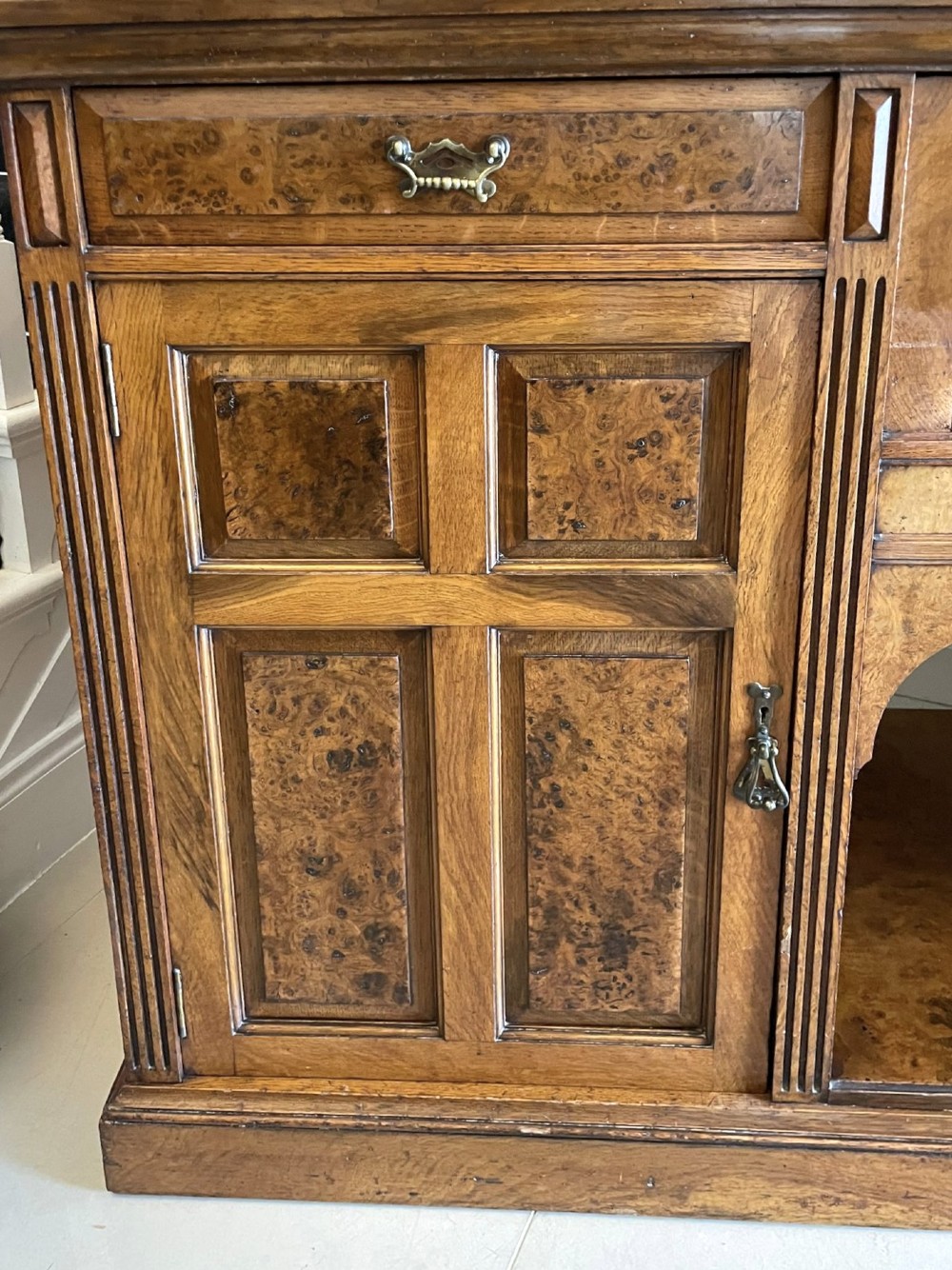 An antique Victorian pollard oak mirror-back sideboard featuring carved field panels, spindled galleries, and multiple mirrored sections. View IX