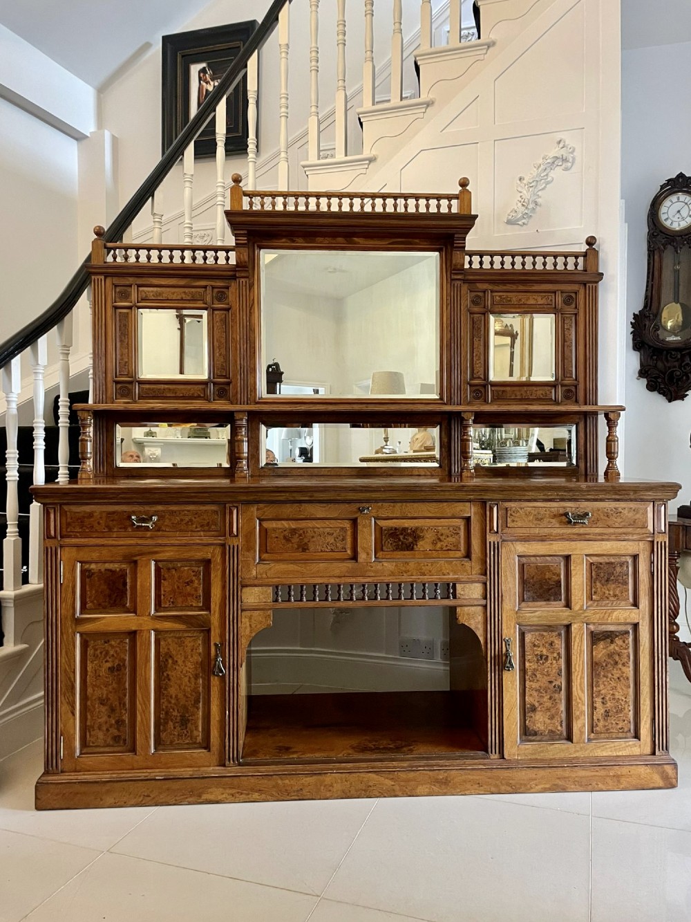 An antique Victorian pollard oak mirror-back sideboard featuring carved field panels, spindled galleries, and multiple mirrored sections.