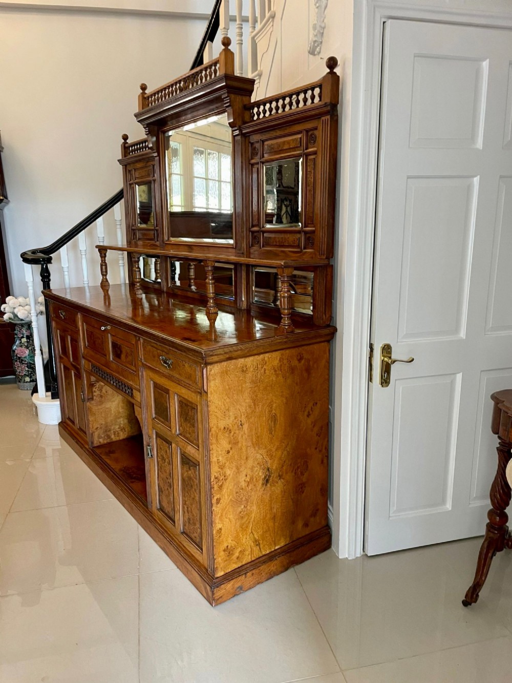 An antique Victorian pollard oak mirror-back sideboard featuring carved field panels, spindled galleries, and multiple mirrored sections. View XI
