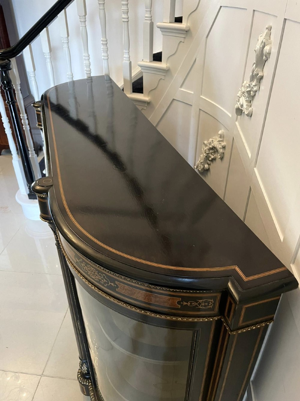 An ebonised nineteenth-century French credenza featuring amboyna wood inlays, gilt-bronze mounts, curved glass door cabinets, and a central painted porcelain plaque. View VI