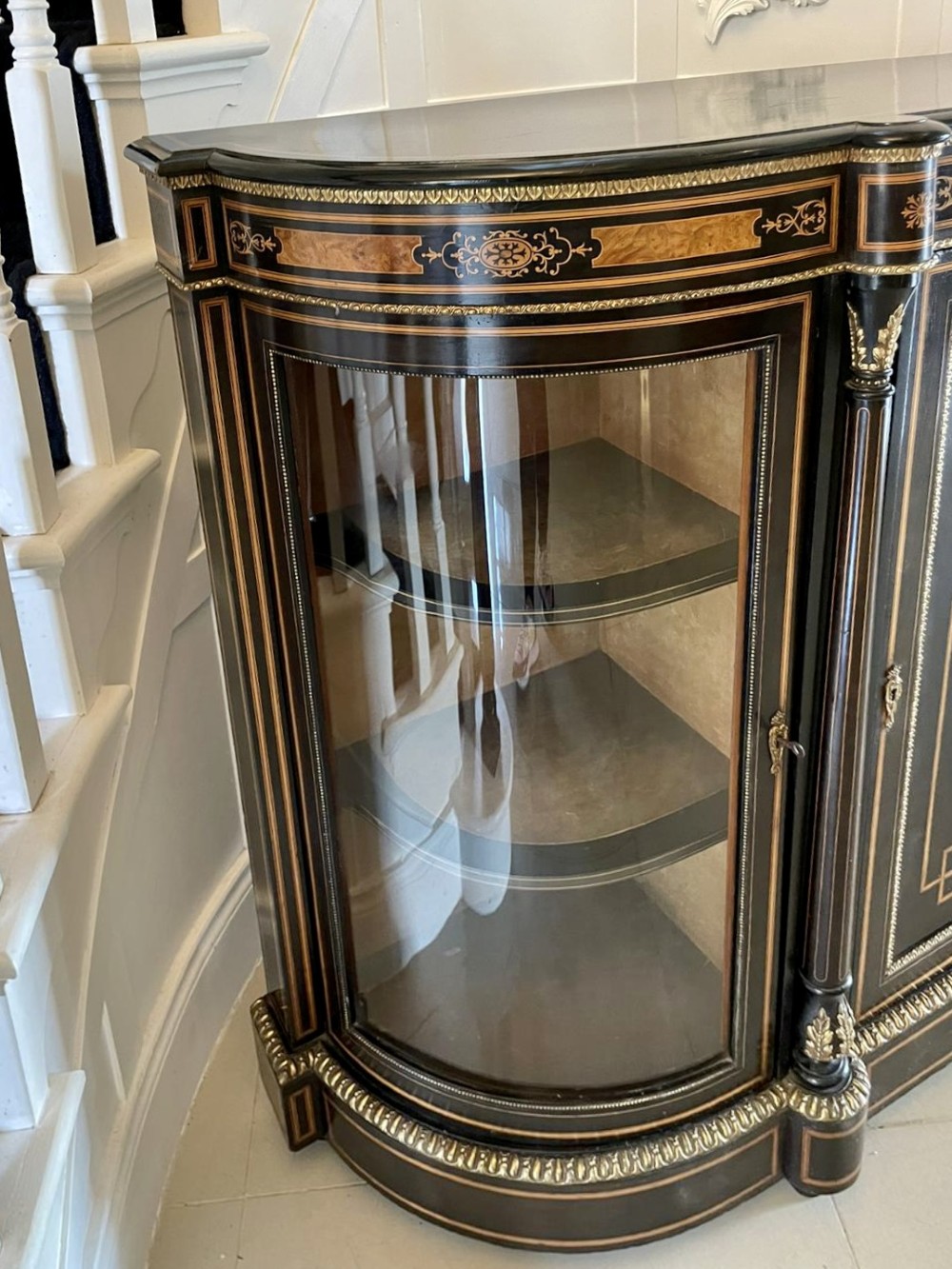 An ebonised nineteenth-century French credenza featuring amboyna wood inlays, gilt-bronze mounts, curved glass door cabinets, and a central painted porcelain plaque. View IX