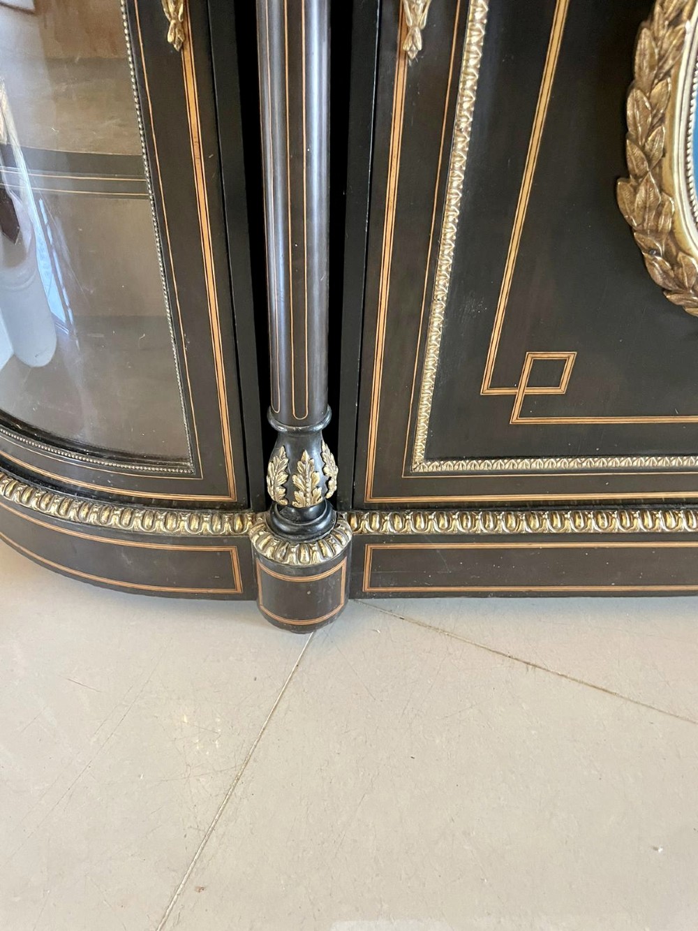 An ebonised nineteenth-century French credenza featuring amboyna wood inlays, gilt-bronze mounts, curved glass door cabinets, and a central painted porcelain plaque. View XII