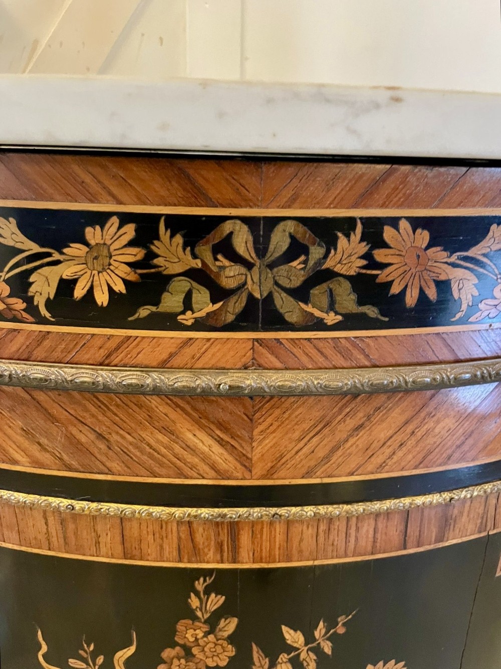 A French Louis XVI style corner cabinet featuring a bow-front door with floral wood marquetry inlay, gilt bronze mounts, and a fitted white marble top. View V