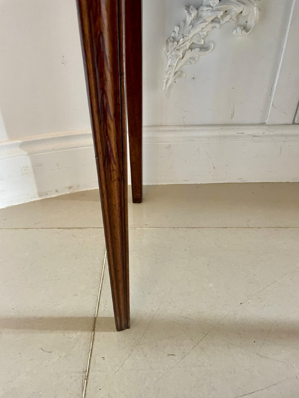 An antique mahogany display cabinet featuring a swan-neck pediment, glazed twin doors, hand-painted floral decoration, and slender tapered legs. View IV