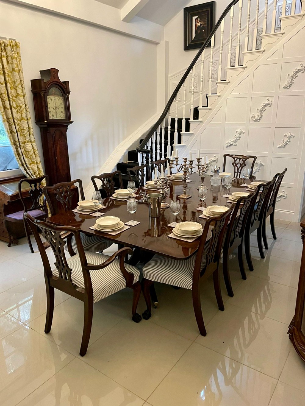A large polished Georgian mahogany three-pedestal dining table supported by turned columns and splayed legs with brass castors. View VI