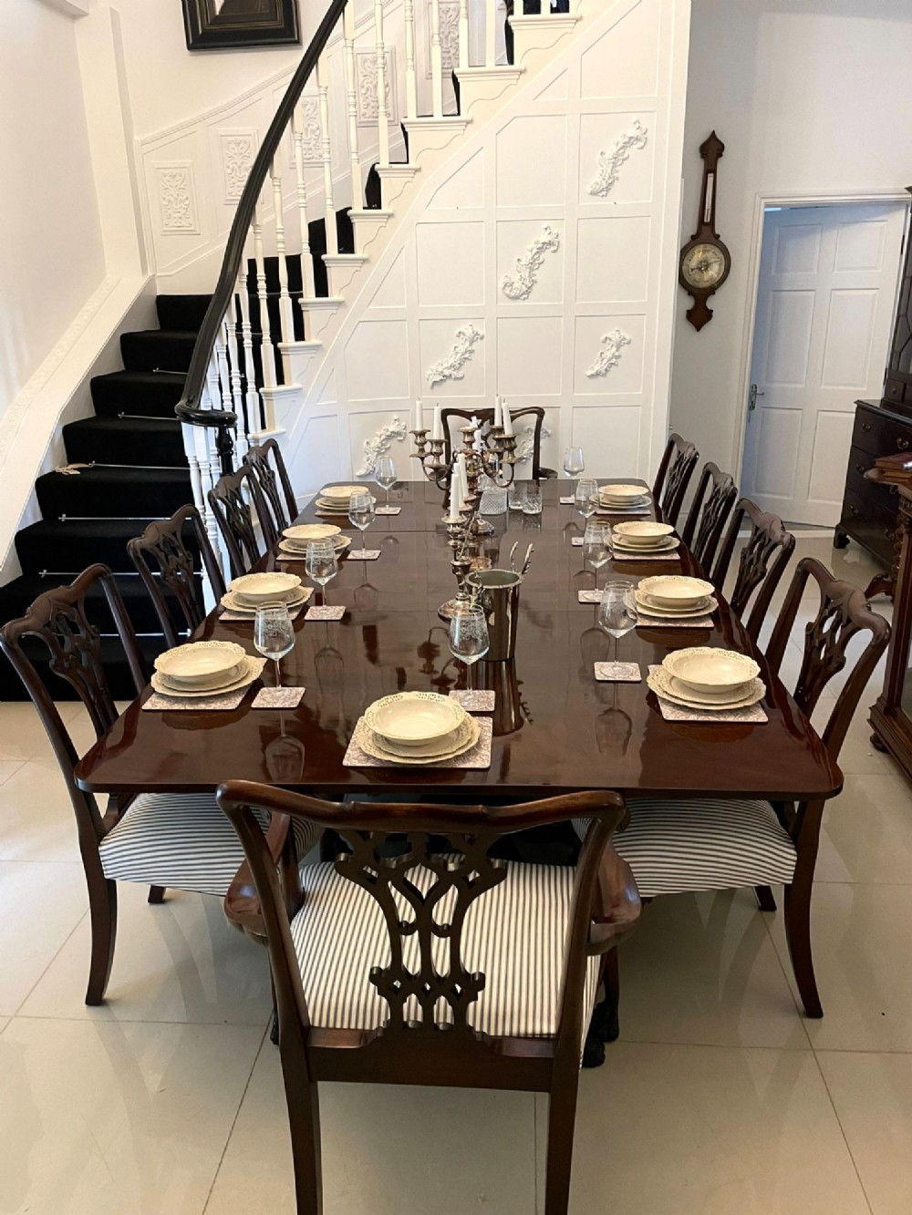 A large polished Georgian mahogany three-pedestal dining table supported by turned columns and splayed legs with brass castors. View VII