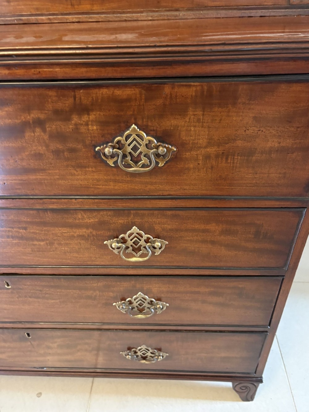 An antique Regency mahogany secretaire bookcase with glazed upper doors featuring curved astragal glazing, resting on a base with four drawers and brass hardware. View VII
