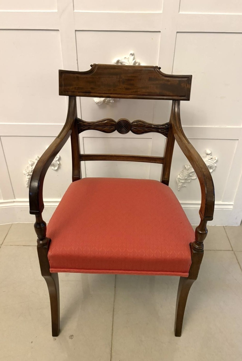 A set of twelve Regency mahogany dining chairs featuring tablet top back rails, carved crossbars, and terracotta fabric upholstered seats, including two carvers with curved armrests. View IV