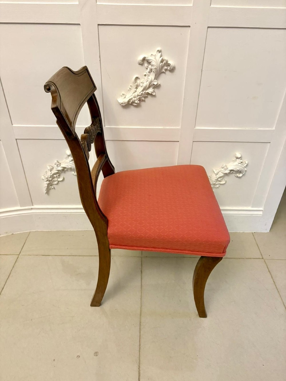 A set of twelve Regency mahogany dining chairs featuring tablet top back rails, carved crossbars, and terracotta fabric upholstered seats, including two carvers with curved armrests. View XIII