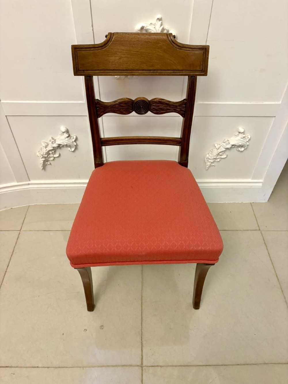 A set of twelve Regency mahogany dining chairs featuring tablet top back rails, carved crossbars, and terracotta fabric upholstered seats, including two carvers with curved armrests. View XIV