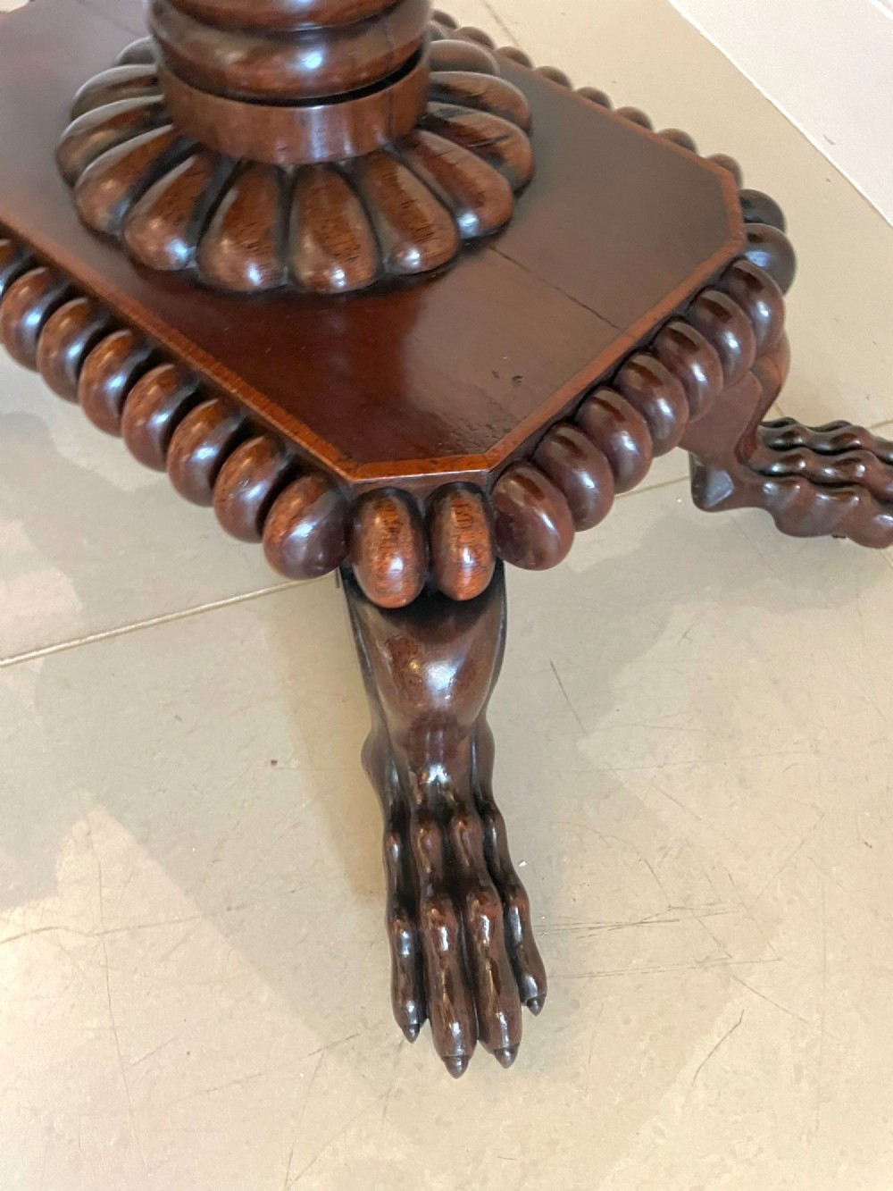 A Regency fold-over rosewood card table with brass inlay, a central pedestal, and carved lion paw feet. View VIII
