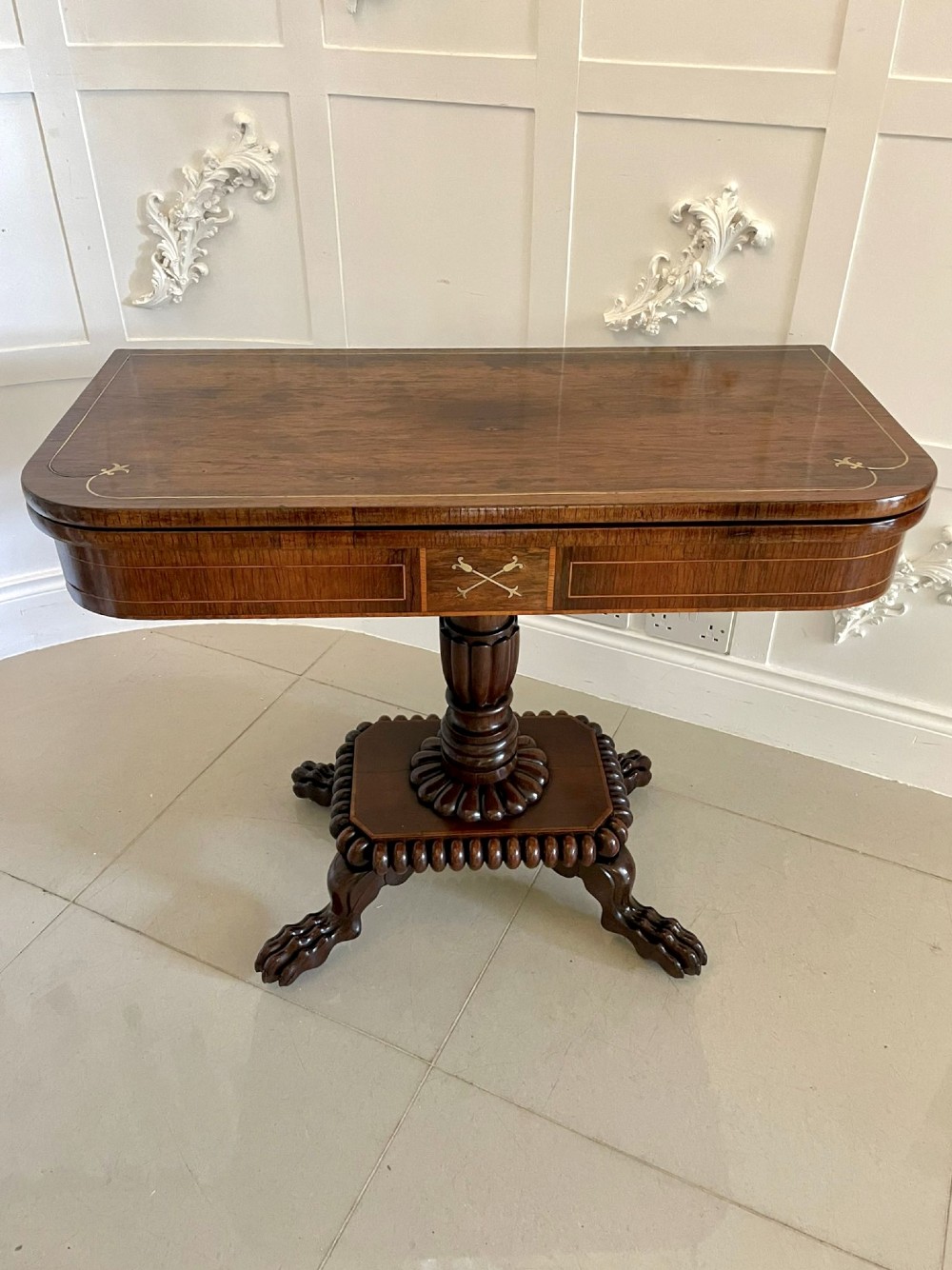 A Regency fold-over rosewood card table with brass inlay, a central pedestal, and carved lion paw feet. View XIII