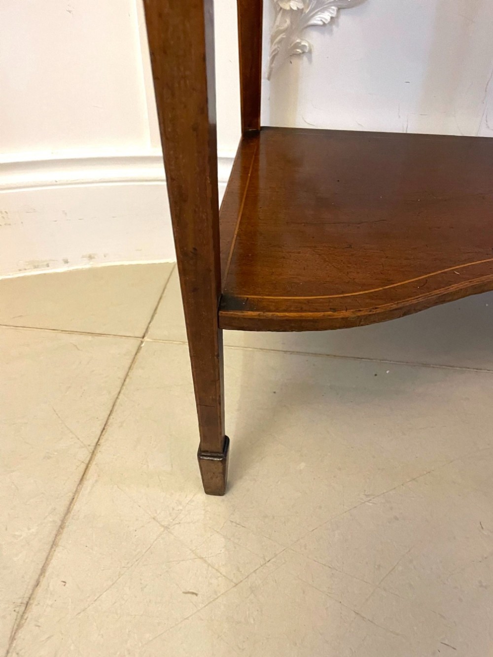 An antique mahogany display cabinet featuring a swan neck pediment, marquetry inlays, glazed double doors, interior glass shelves, and square tapered legs. View VII