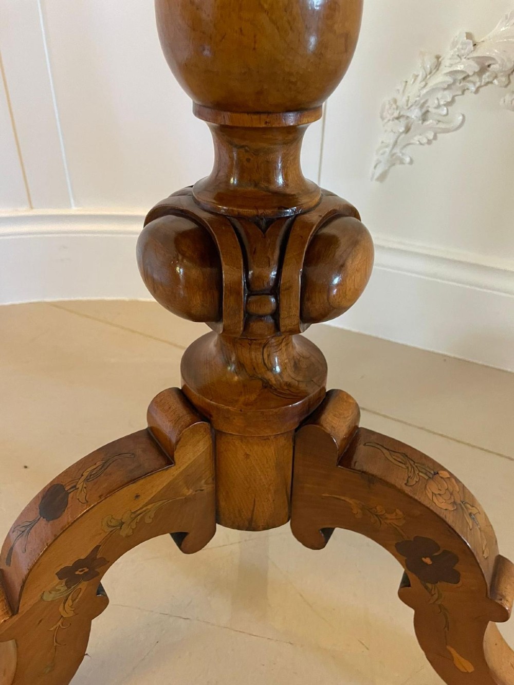 A Victorian walnut occasional table featuring a scalloped rim, intricate marquetry floral inlay on the tabletop, a turned central pedestal, and three carved cabriole legs. View VII