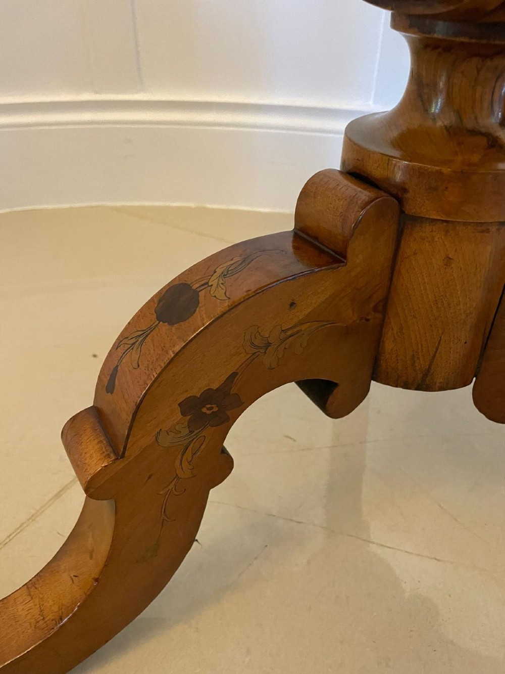 A Victorian walnut occasional table featuring a scalloped rim, intricate marquetry floral inlay on the tabletop, a turned central pedestal, and three carved cabriole legs. View VIII