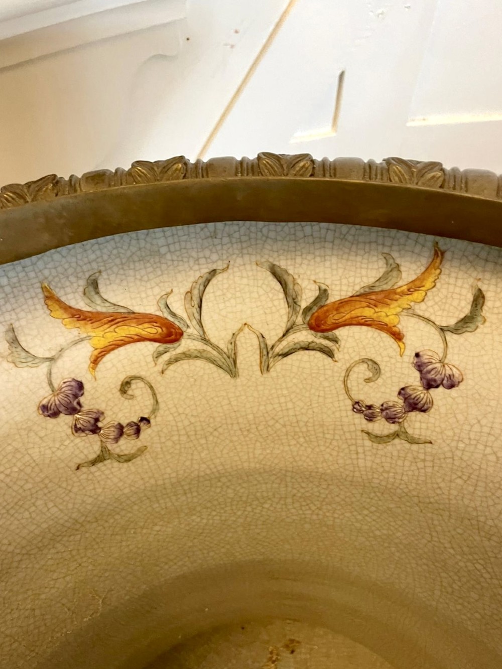 A pair of black French porcelain jardiniere urns featuring polychrome floral enamel, central painted animal reserves, and gadrooned brass mounts on square plinths. View VII
