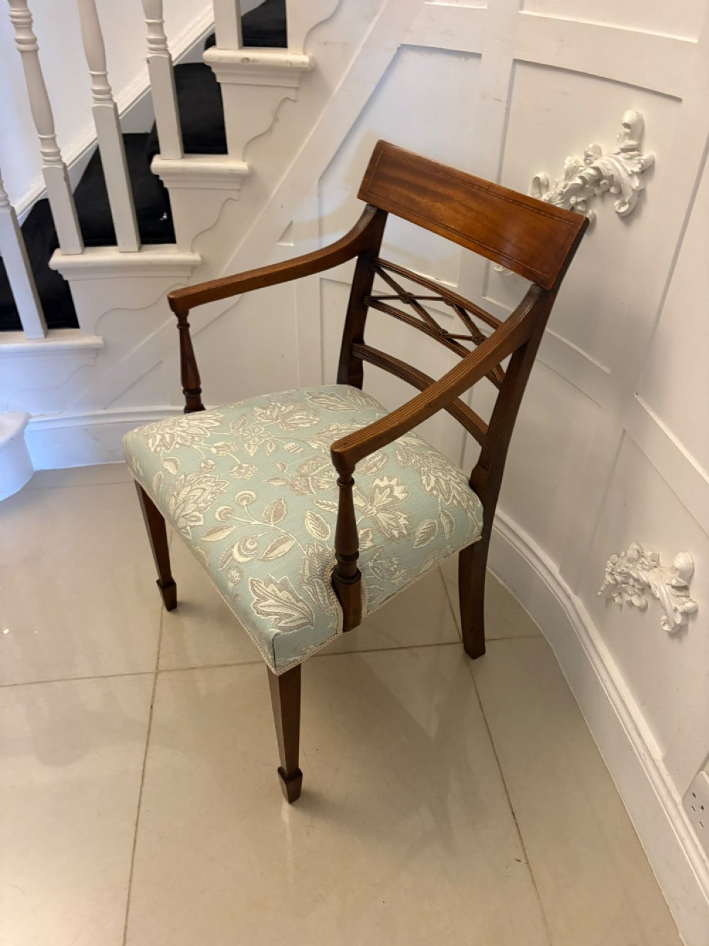 A set of ten Edwardian mahogany dining chairs, including two carver armchairs, featuring lattice backrests and pale blue patterned fabric upholstery. View VI
