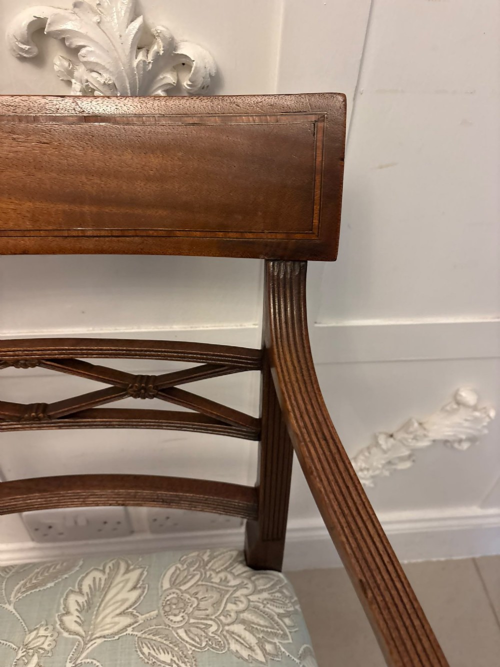 A set of ten Edwardian mahogany dining chairs, including two carver armchairs, featuring lattice backrests and pale blue patterned fabric upholstery. View VIII