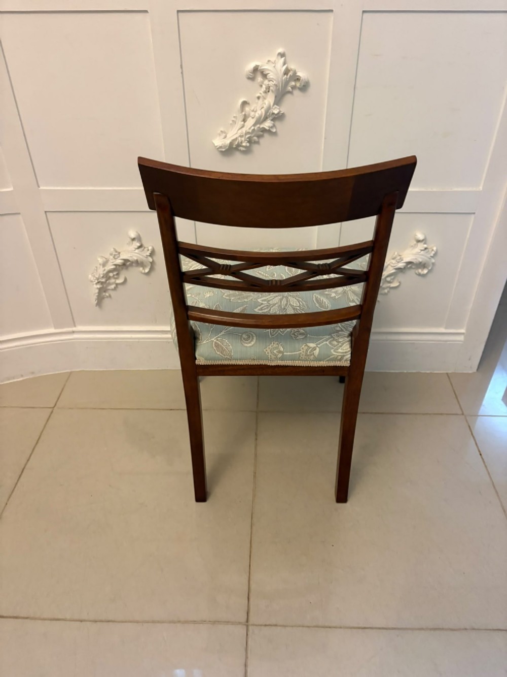 A set of ten Edwardian mahogany dining chairs, including two carver armchairs, featuring lattice backrests and pale blue patterned fabric upholstery. View IX