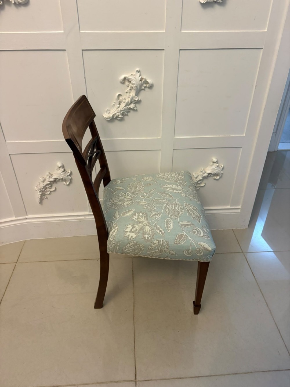 A set of ten Edwardian mahogany dining chairs, including two carver armchairs, featuring lattice backrests and pale blue patterned fabric upholstery. View X