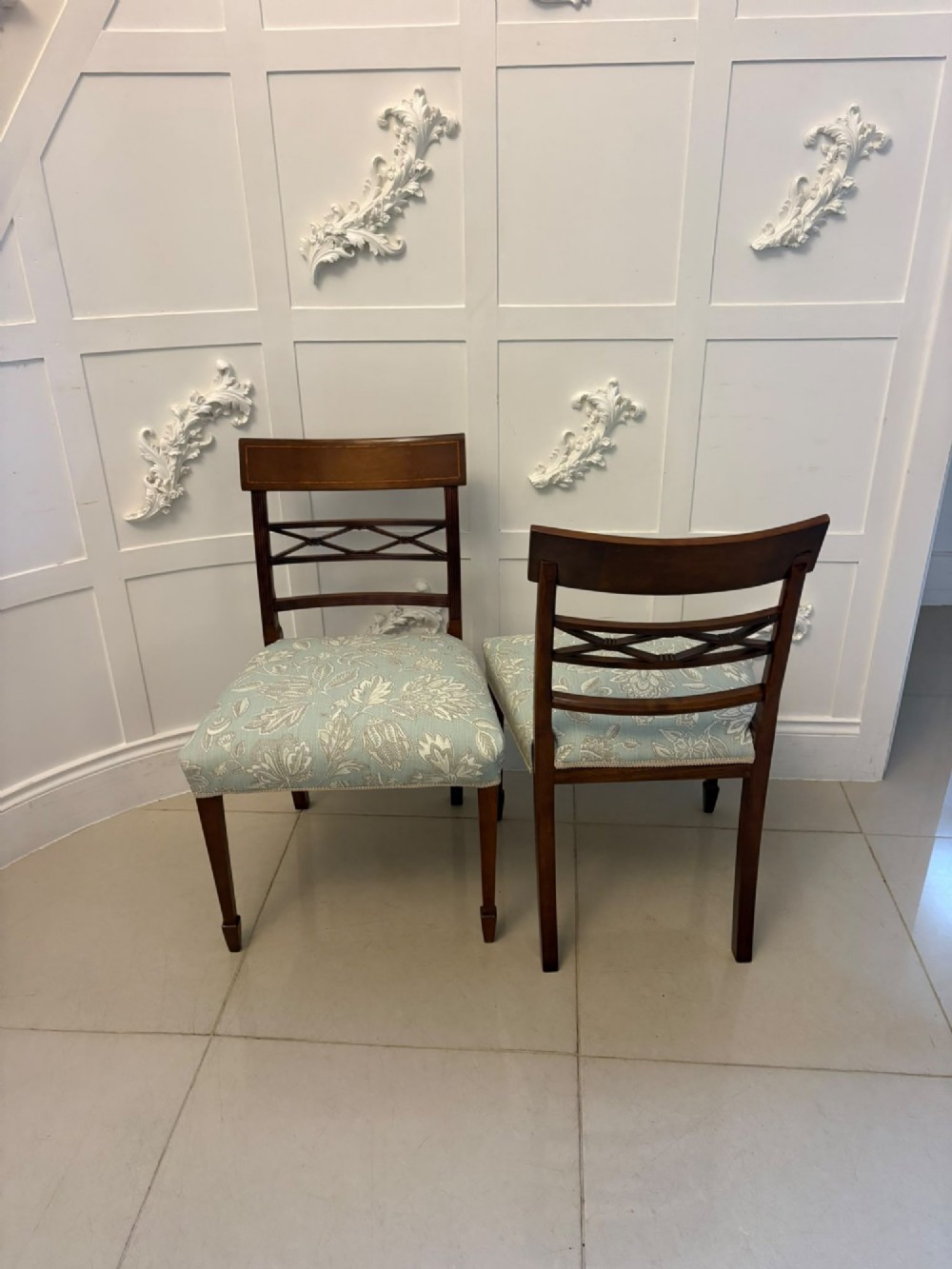 A set of ten Edwardian mahogany dining chairs, including two carver armchairs, featuring lattice backrests and pale blue patterned fabric upholstery. View XI