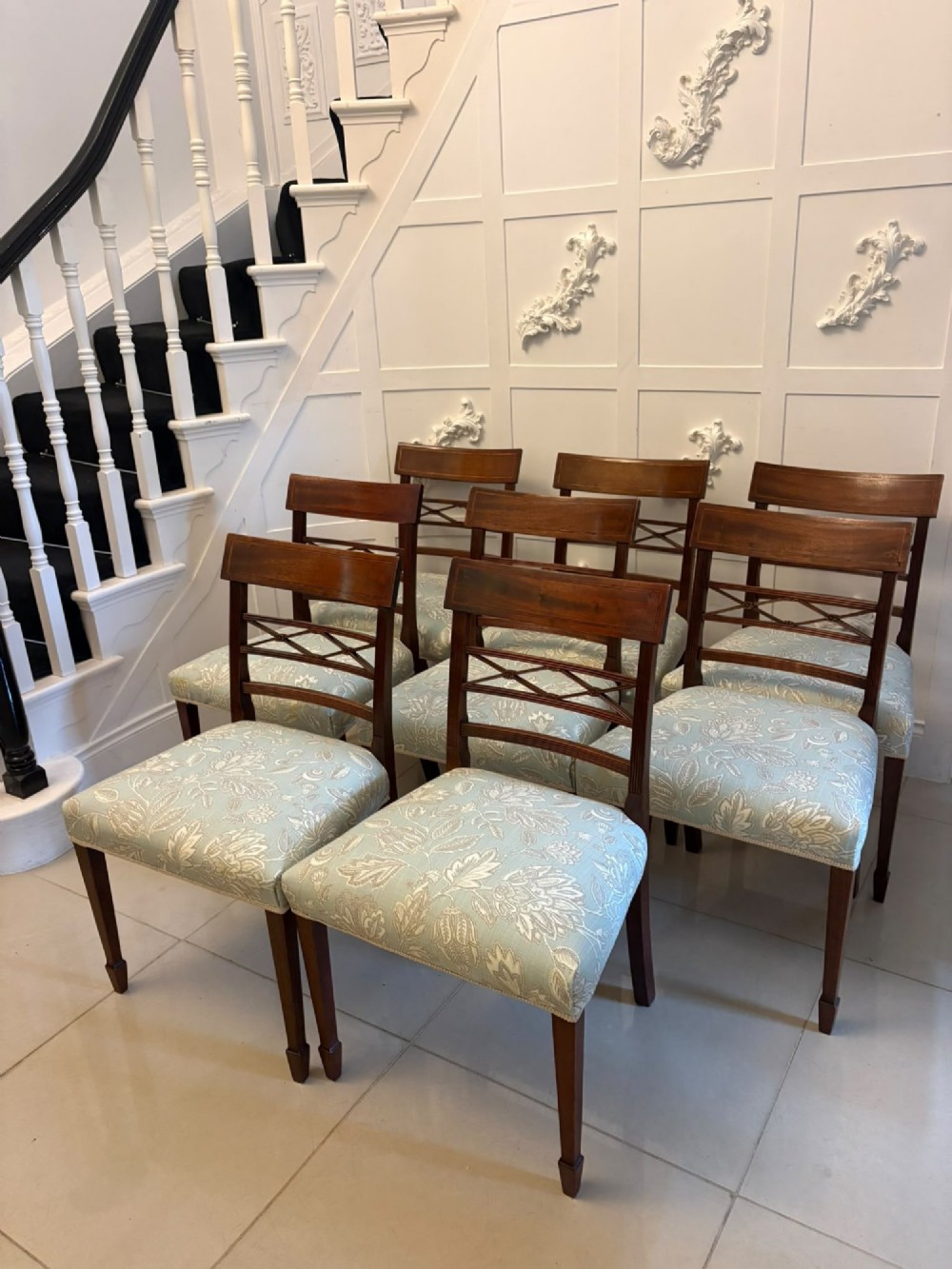 A set of ten Edwardian mahogany dining chairs, including two carver armchairs, featuring lattice backrests and pale blue patterned fabric upholstery. View XII