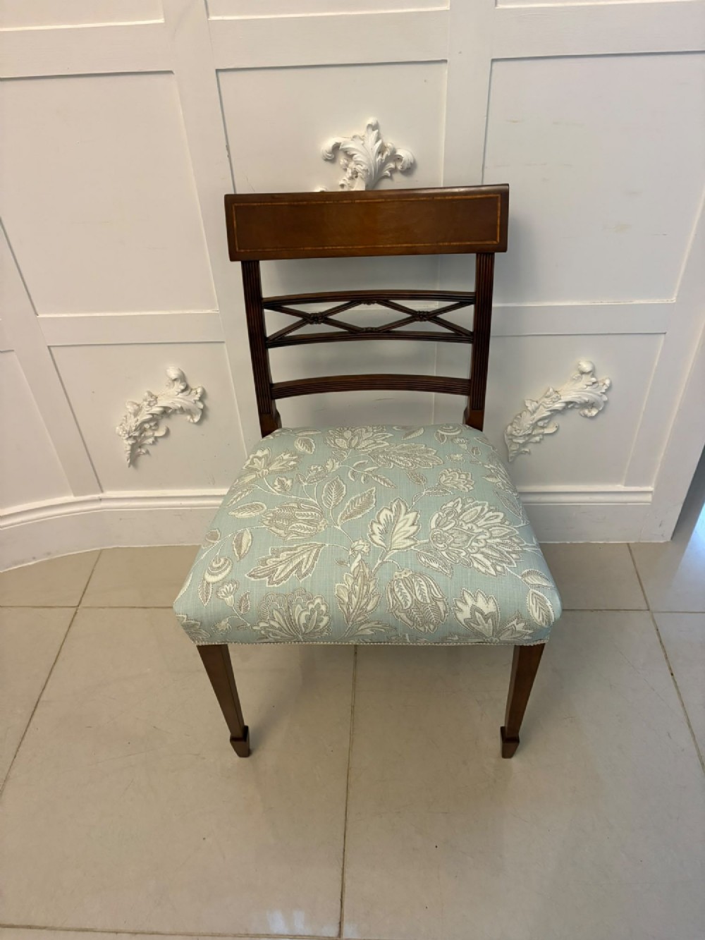 A set of ten Edwardian mahogany dining chairs, including two carver armchairs, featuring lattice backrests and pale blue patterned fabric upholstery. View XV