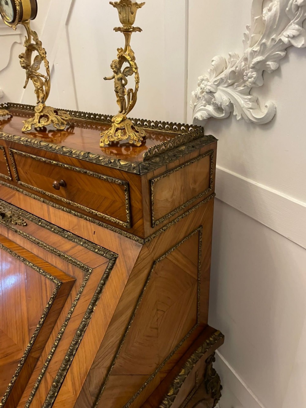 A French Rococo revival slant-front kingwood bureau featuring delicate ormolu mounts, a central hand-painted porcelain plaque, and elegant cabriole legs. View V