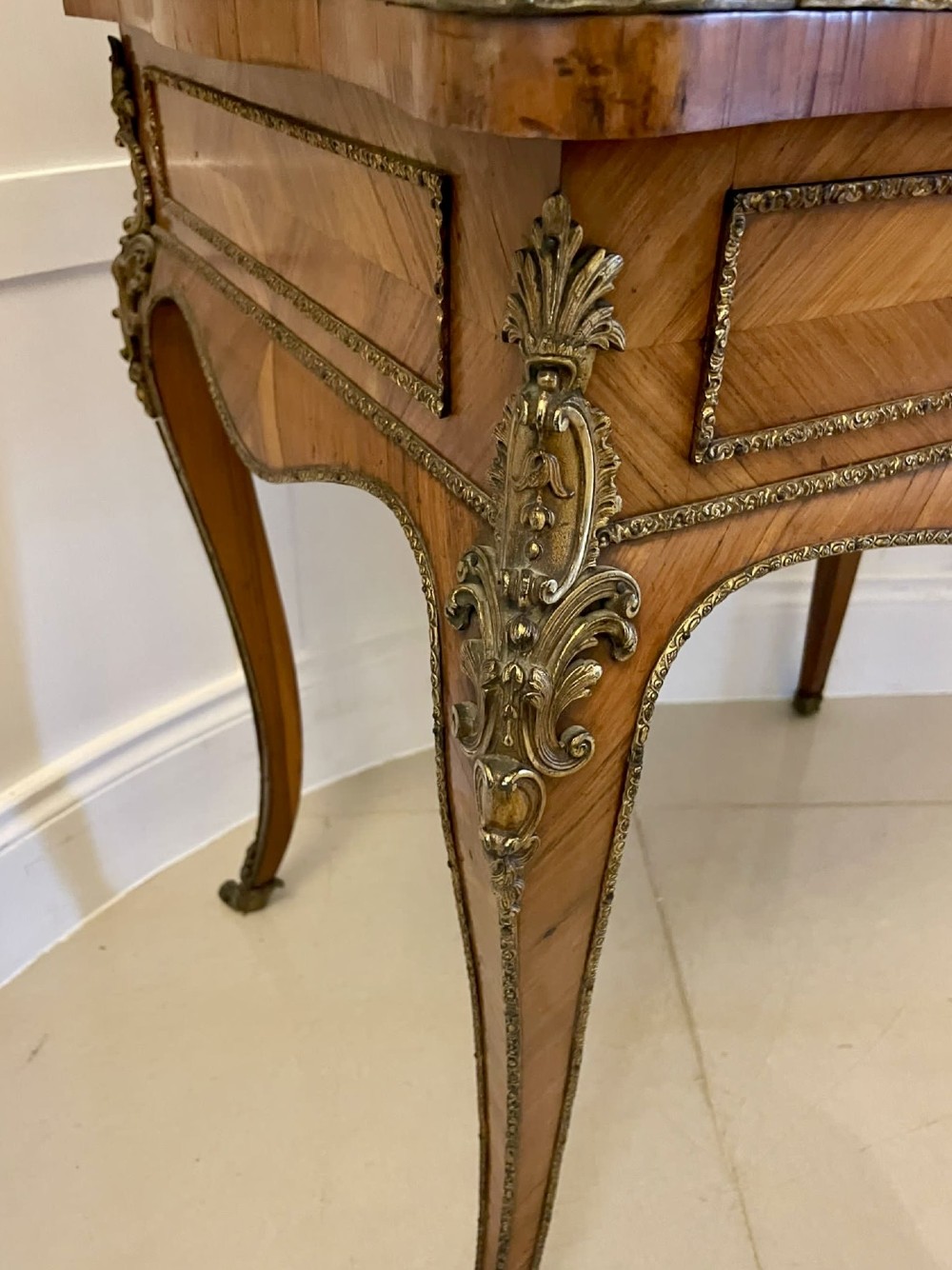 A French Rococo revival slant-front kingwood bureau featuring delicate ormolu mounts, a central hand-painted porcelain plaque, and elegant cabriole legs. View IX