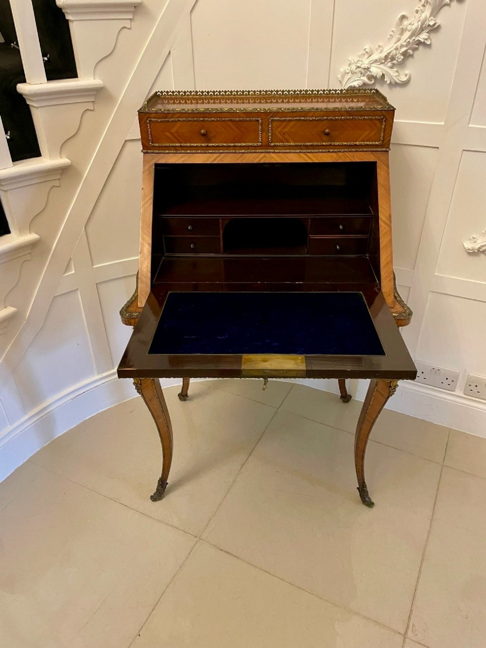 A French Rococo revival slant-front kingwood bureau featuring delicate ormolu mounts, a central hand-painted porcelain plaque, and elegant cabriole legs. View XIII