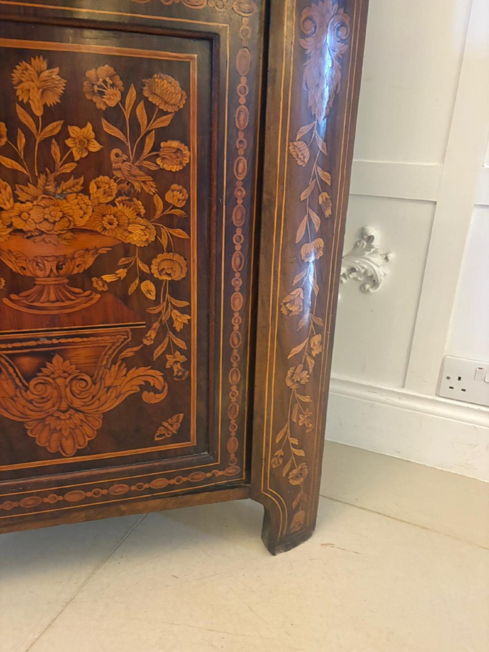 A 19th-century two-tier Dutch marquetry corner cabinet featuring intricate floral inlays, an arched glazed top door, and a solid lower cupboard door. View II