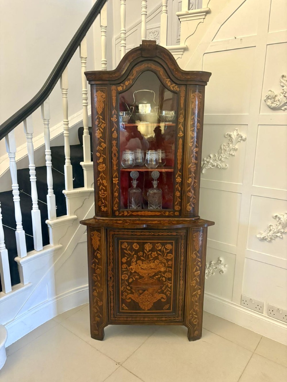 A 19th-century two-tier Dutch marquetry corner cabinet featuring intricate floral inlays, an arched glazed top door, and a solid lower cupboard door. View III