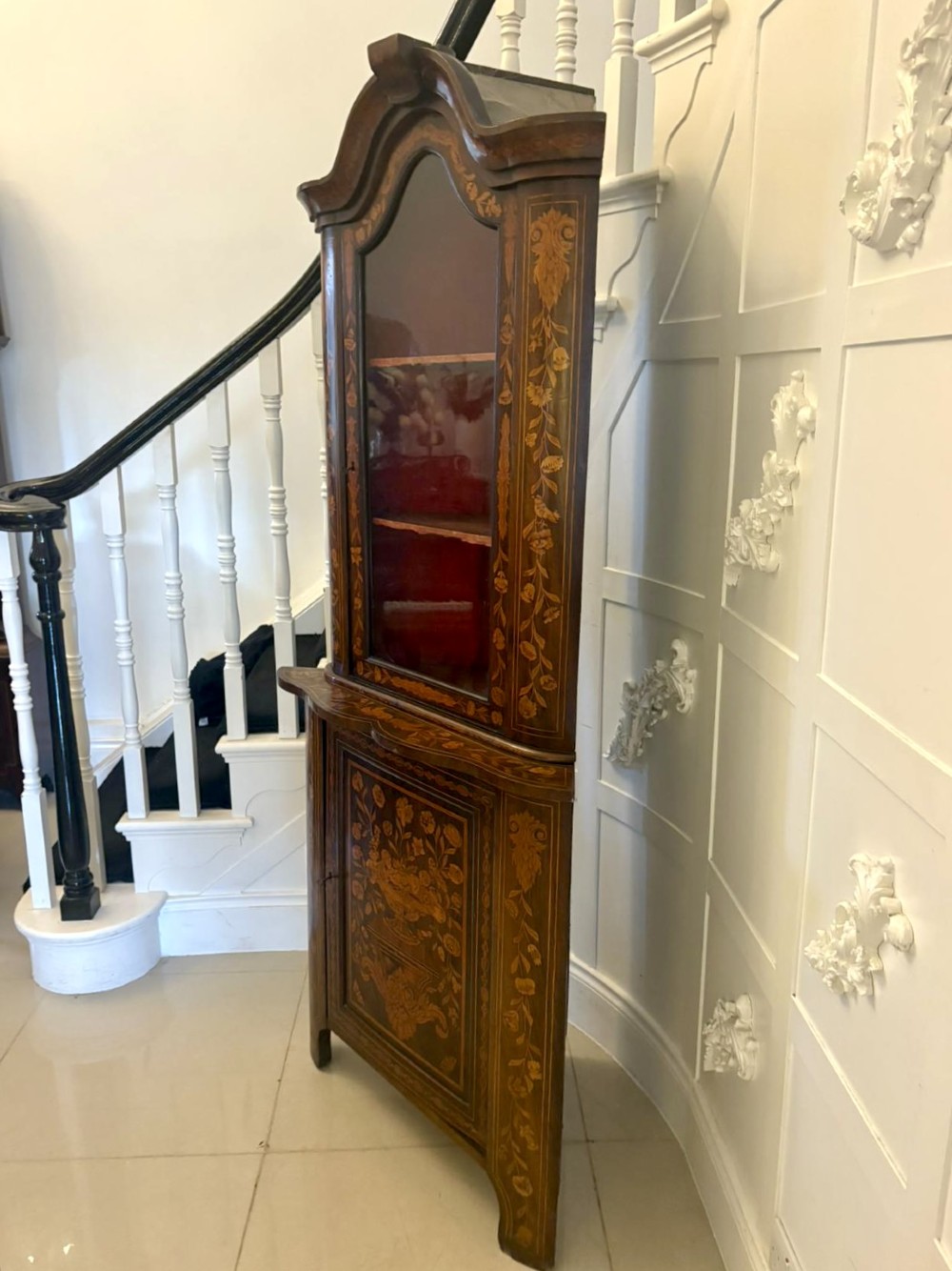 A 19th-century two-tier Dutch marquetry corner cabinet featuring intricate floral inlays, an arched glazed top door, and a solid lower cupboard door. View X