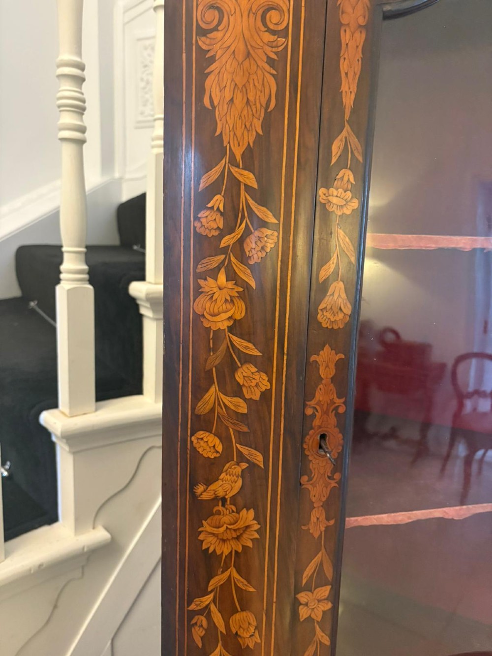 A 19th-century two-tier Dutch marquetry corner cabinet featuring intricate floral inlays, an arched glazed top door, and a solid lower cupboard door. View XI