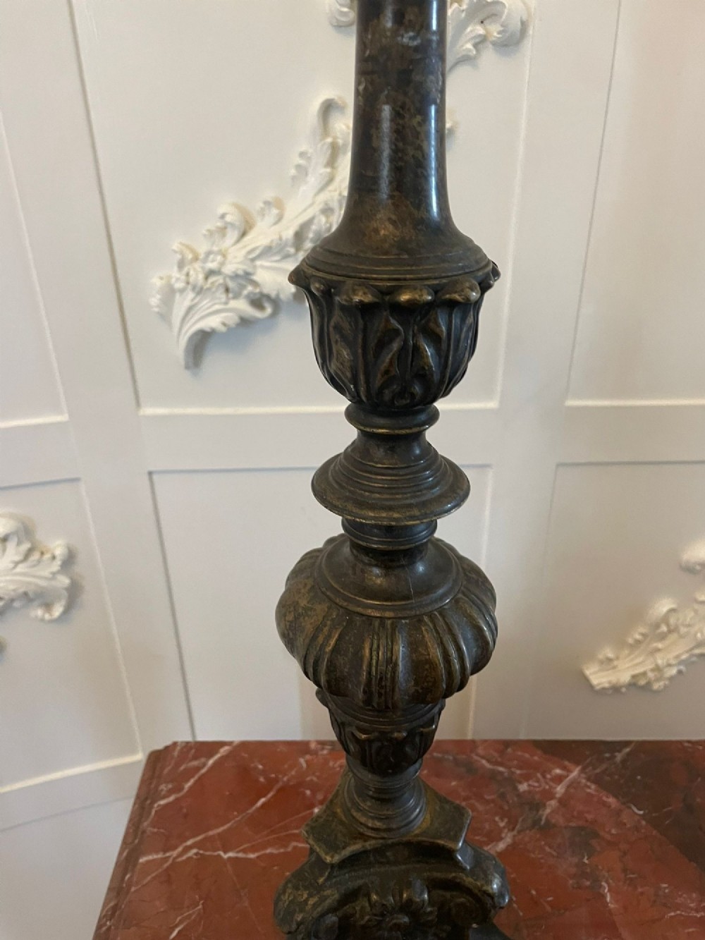 A pair of tall antique Victorian brass pricket candlesticks featuring ornate baluster shafts, foliate details, and spiked drip pans resting on decorative tripod bases. View VII
