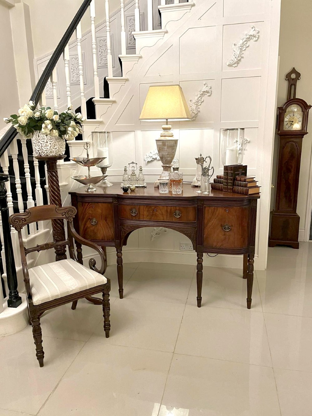 An antique George III mahogany breakfront sideboard featuring flame mahogany drawer fronts, reeded legs, and central drawer flanked by cupboards. View XI