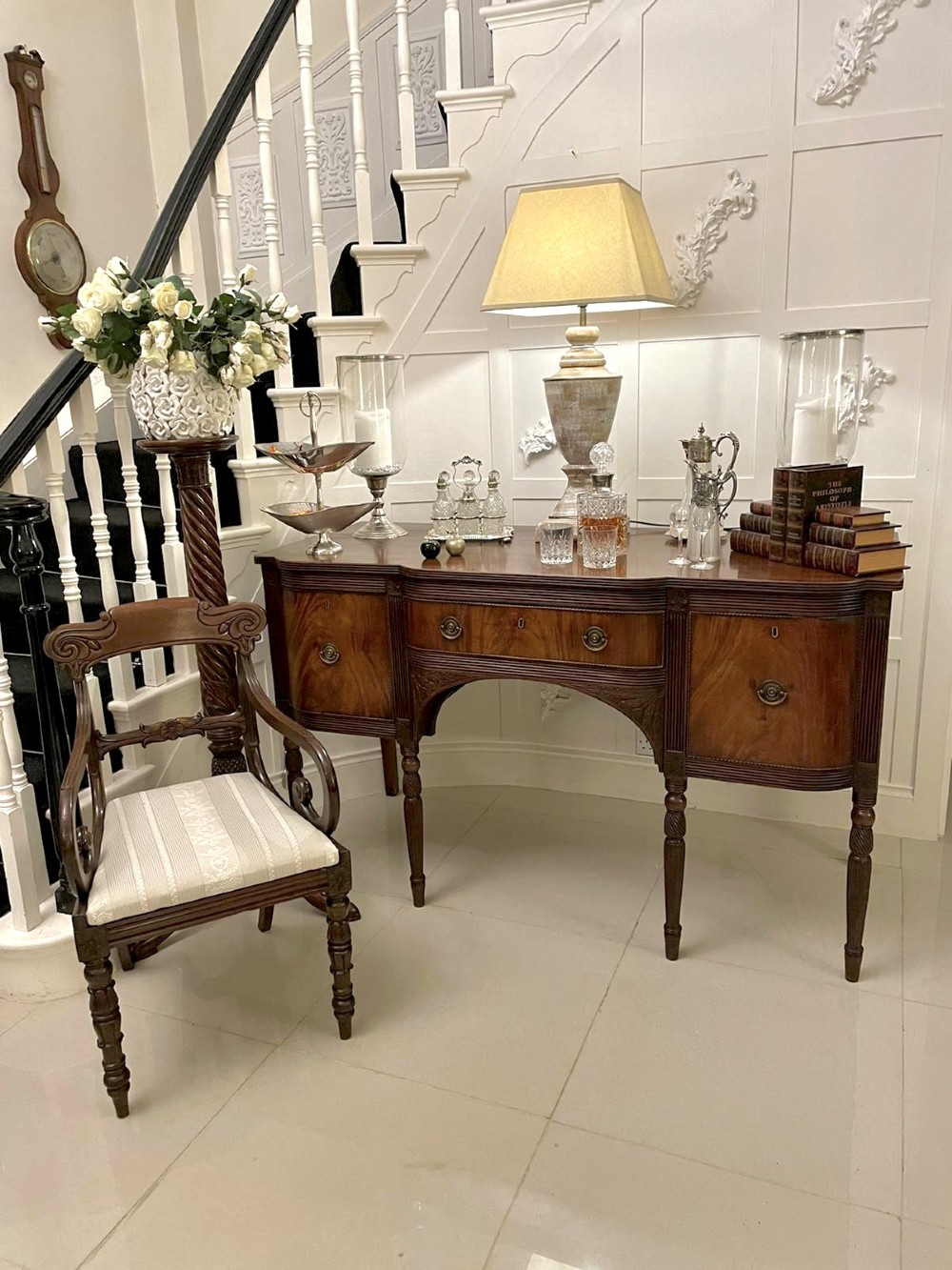 An antique George III mahogany breakfront sideboard featuring flame mahogany drawer fronts, reeded legs, and central drawer flanked by cupboards. View XII