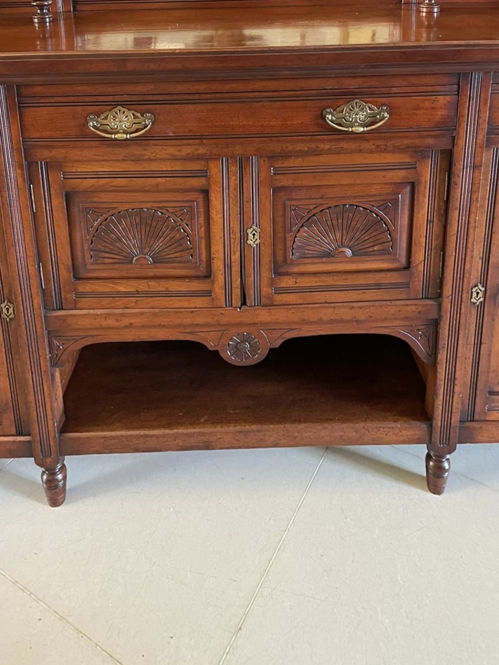 A carved walnut Victorian mirror-back sideboard featuring turned columns, carved fan panels, multiple mirrors, and brass drawer handles. View XII