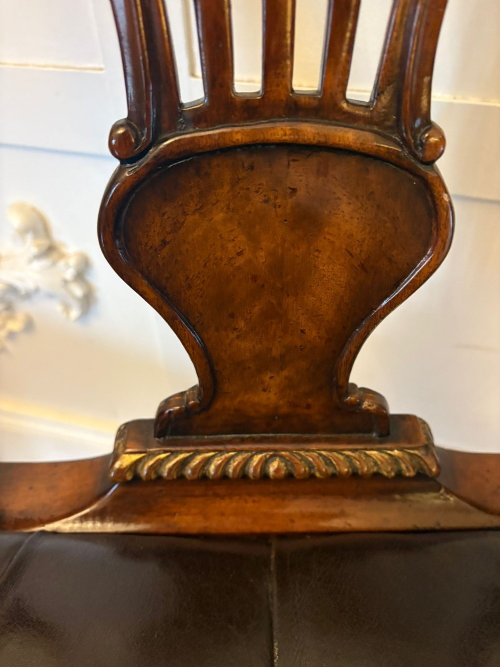 Set of eight Edwardian carved walnut dining chairs featuring pierced backrests, gilded highlights, cabriole legs, and dark brown button-tufted leather seats. View II