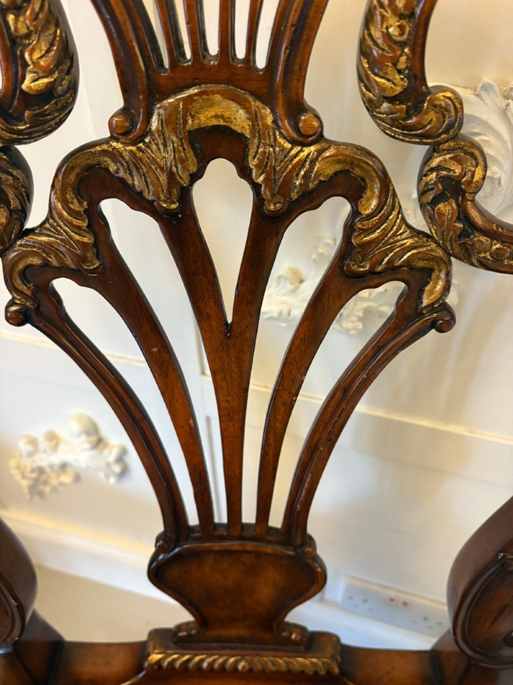 Set of eight Edwardian carved walnut dining chairs featuring pierced backrests, gilded highlights, cabriole legs, and dark brown button-tufted leather seats. View IV