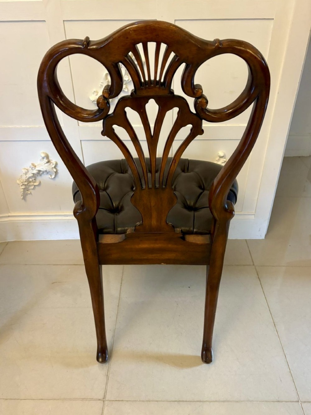 Set of eight Edwardian carved walnut dining chairs featuring pierced backrests, gilded highlights, cabriole legs, and dark brown button-tufted leather seats. View XII