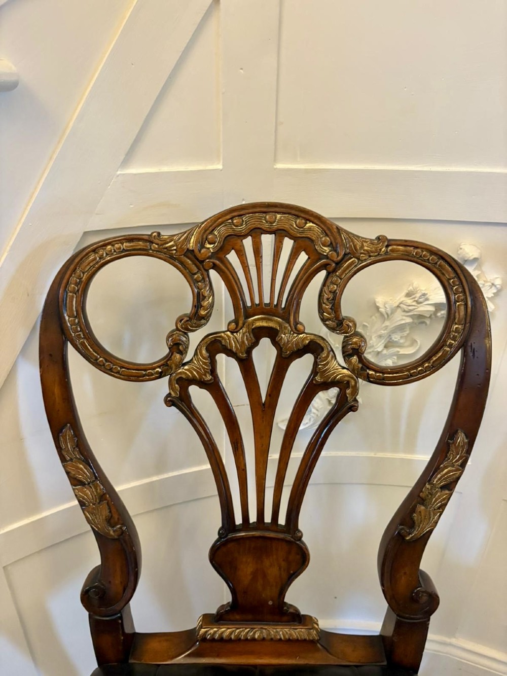 Set of eight Edwardian carved walnut dining chairs featuring pierced backrests, gilded highlights, cabriole legs, and dark brown button-tufted leather seats. View XIV