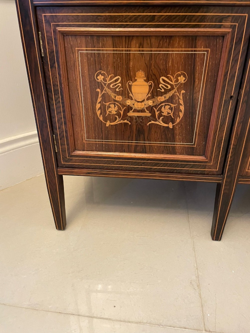 An antique Victorian dark rosewood side cabinet featuring intricate floral inlay, multiple bevelled mirror sections, open shelving, and a central cupboard door. View VII