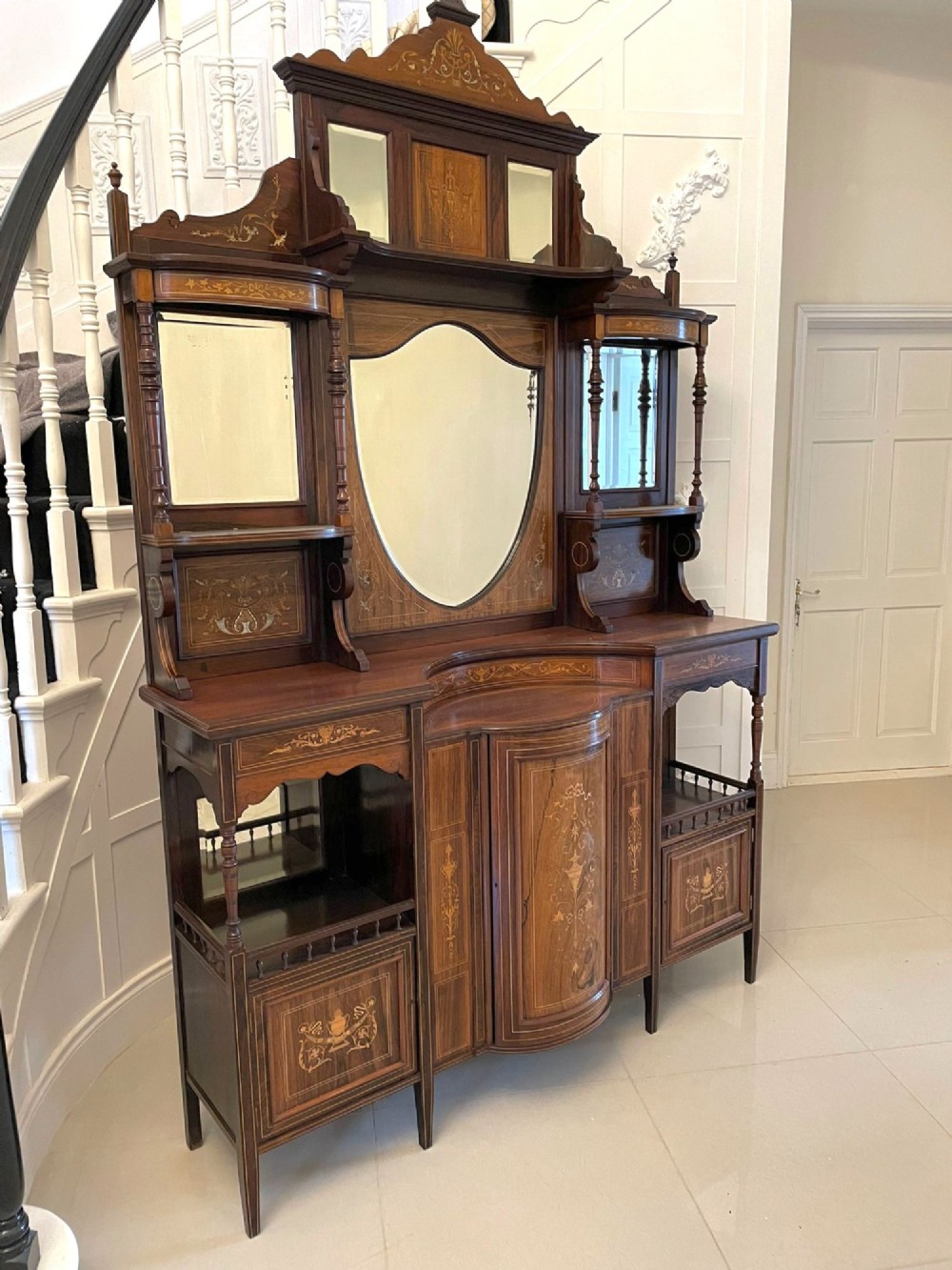 An antique Victorian dark rosewood side cabinet featuring intricate floral inlay, multiple bevelled mirror sections, open shelving, and a central cupboard door. View VIII